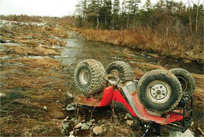 ATV flipped over in the mud 